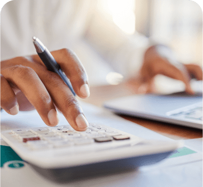Hands using calculator and laptop.